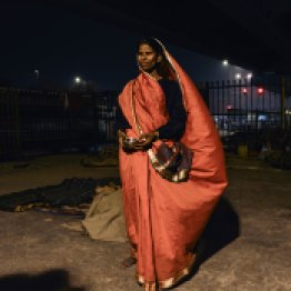 Snigdha Kumari resides under the flyover of Sarai Kale Khan, South Delhi. She posed for a beautiful portrait in her orange saree while her kids went to sleep.